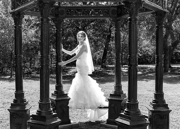 Bride holding pillars of gazebo