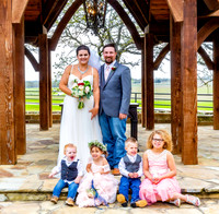 Bride and groom poisng with children